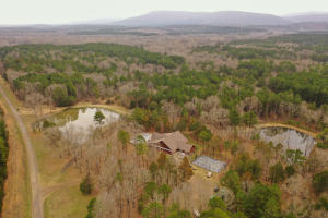 The property that will check all of your boxes! Starting with 95+/- beautiful acres with 2841sqft main home and 1260sqft cabin. Located about 6 miles south of Booneville Arkansas is this amazing property bordered on 3 sides by 16,500 acres of Blue Mountain Demonstration area and WMA. There is a nice touchpad coded gated entrance for privacy and security. As you drive into the property the main home is on your right overlooking 2 beautiful stocked ponds. The spectacular custom built 2841sqft 3 bedroom 2 1/2 bath single story home features large cathedral ceilings, dry stack indoor and outdoor fireplace, custom cabinets, stainless steel appliances, outdoor patio, hot tub and in ground pool that overlooks the 1 acre stocked pond.