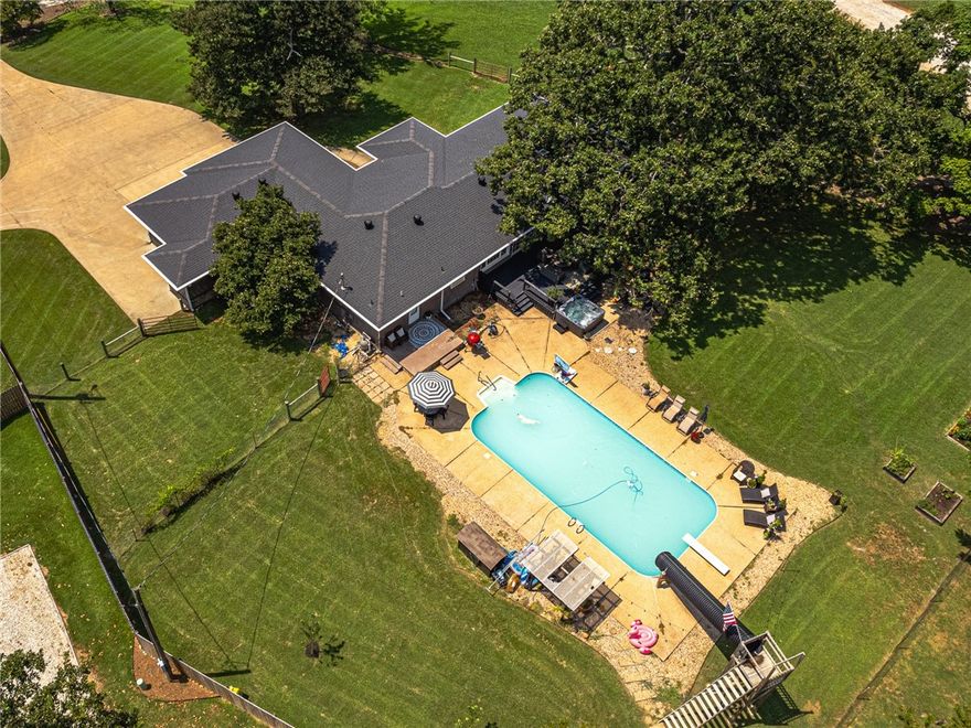 Prime Location: Bentonville Schools, Bentonville West HS, just 2 miles from I-49 and 8 miles from Downtown Bentonville! Welcome to this stunning 2,209 sq.ft. home boasting a bright, open floor plan with 3 bedrooms and 2 baths. Features include elegant built-ins, durable Pergo flooring, and brick/vinyl shake siding. Full 3-car garage with safe room/tornado shelter inside. Cozy wood-burning fireplace with steel liner & blower. Ample storage throughout. Large swimming pool, one-of-a-kind slide, and hot tub for relaxation. Beautiful 1.02-acre lot with mature shade trees, gardening beds, fruit trees, covered porches, and decks for outdoor living. Fully fenced yard with well house (public water option available; owner enjoys abundant, high-quality well water). Unique Opportunity: Previously a highly successful Airbnb, consistently fully booked! Ideal for families or investors seeking versatility. Seller offers $10,000 concession toward buyer’s closing costs. Don’t miss this move-in-ready gem blending comfort and charm.