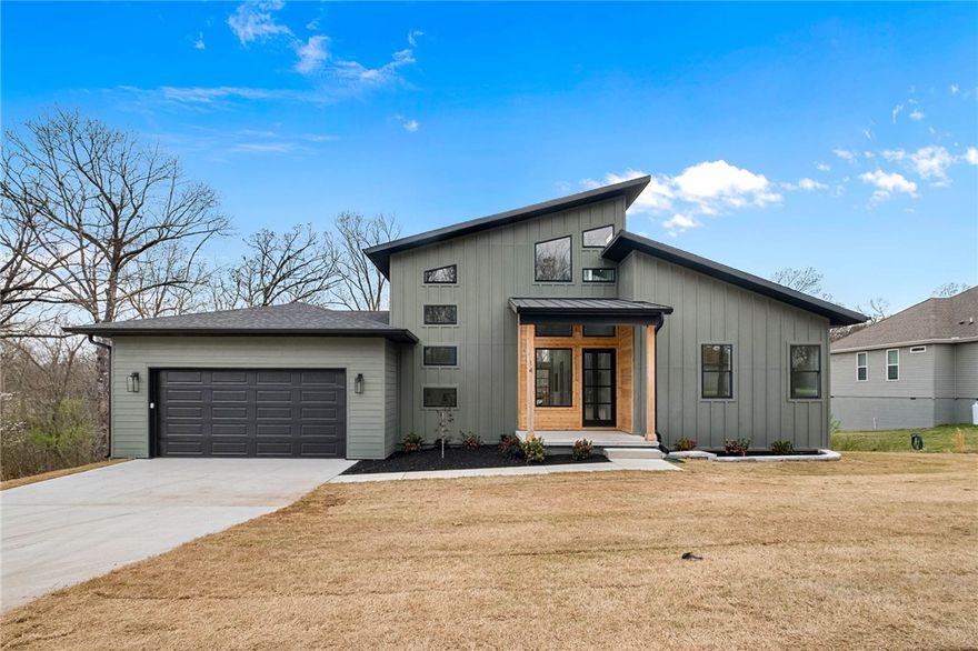 Welcome to this stunning new construction home in beautiful Bella Vista! This modern 3-bedroom, 2-bath residence offers 2,113 sq ft of thoughtfully designed living space on a 0.37-acre lot. Built with both style and durability in mind, the home showcases exceptional craftsmanship and high-end finishes throughout. Step inside to an open-concept living area highlighted by soaring 24-ft ceilings and a dramatic 22-ft fireplace wrapped in premium quartz. The kitchen and bathrooms feature custom white oak cabinetry, designer quartz countertops, and a full-height backsplash, creating a sleek modern aesthetic. Custom 8-ft doors and a high-end window package bring in abundant natural light. The split-bedroom layout provides privacy, while the primary suite offers a relaxing retreat. Located just minutes from bike trails and Bella Vista amenities. Energy-efficient construction, quality materials, and modern design make this home built to last.