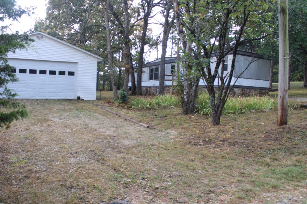 Here's Your Lake Get-A-Way - Home Plus 24 x 36 ft Garage / Shop Building - great for boat storage, workshop or both. Includes 2 bed/ 2 bath manufactured home, split bedroom plan, living - dining - kitchen combo with vaulted ceiling, rear deck with ramp for easy access, new mini split system, new interior paint, new roof coating Plus a 24 x 36 ft detached garage with vinyl siding, metal roof, & electricity. Home connected to public water and sewer, plus water & sewer are beside the garage in case you want to add a bath or efficiency apartment inside the garage. Sits on 2 lots with lots of shade trees only a few minutes north to Lake Bull Shoals with Corp of Engineers maintained park, boat launch and marina or a few minutes to south to 18-hole golf course. Shopping, post office, and bank only a few miles away, about 30 minutes to Harrison or 40 minutes to Branson, MO. Come See - Make this your get-a-way place or permanent residence.