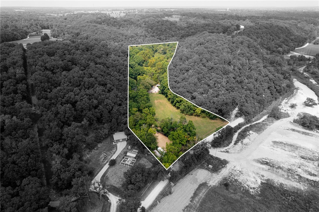 Don't miss your opportunity to secure build-ready acreage with long-term potential. Set on 5 acres just minutes from Downtown Bentonville, this equine-ready property blends open pasture with functional facilities and future potential. A well-maintained barn, arena, and fencing make it ideal for horses or a private estate. The parcel includes part of the hillside, leaving room for a future driveway that could connect to Sugar Creek if additional land is developed. The flat acreage is easily buildable, while existing improvements add value: a private well and equine infrastructure provide immediate utility for any future owner. Located only 12 minutes or 6 miles from downtown Bentonville, the property offers rural charm with close city access. This tract reflects both land value and thoughtful enhancements.