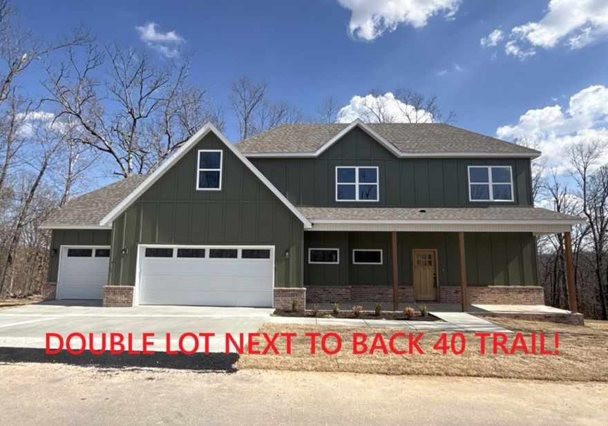 New construction with a 3 car garage and bonus room on a .46 acre wooded double lot next to the Back 40 Trail! This stunning property offers the perfect blend of nature and nearby amenities. Step inside to discover a beautiful fireplace, custom cabinets, gas range, and elegant 3 cm quartz countertops. This thoughtfully designed home features 3 spacious bedrooms plus a versatile bonus room, providing ample space for entertainment. The primary bedroom is conveniently located on the main level. Bentonville schools! As an added bonus, this home includes $3,500 in buyer's closing costs when using the builder’s preferred lender!