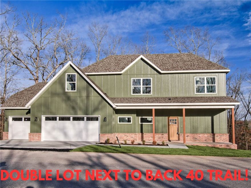 New construction with a 3 car garage and bonus room on a .46 acre wooded double lot next to the Back 40 Trail! This stunning property offers the perfect blend of nature and nearby amenities. Step inside to discover a beautiful fireplace, custom cabinets, gas range, and elegant 3 cm quartz countertops. This thoughtfully designed home features 3 spacious bedrooms plus a versatile bonus room, providing ample space for entertainment. The primary bedroom is conveniently located on the main level. Bentonville schools! As an added bonus, this home includes $3,500 in buyer's closing costs when using the builder’s preferred lender!