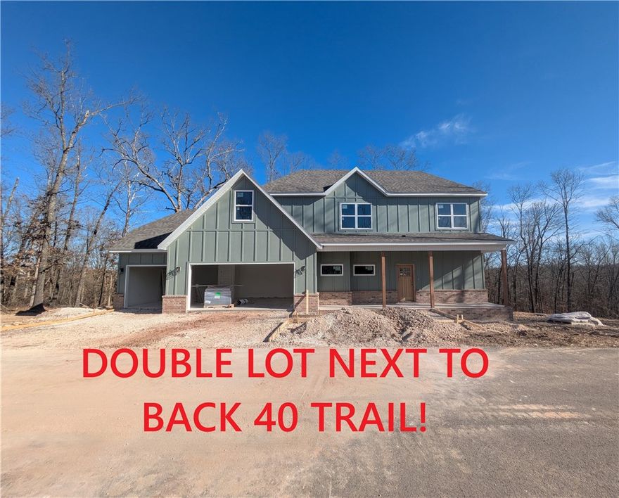 New construction with a 3 car garage and bonus room on a .46 acre wooded double lot next to the Back 40 Trail! This stunning property offers the perfect blend of nature and nearby amenities. Step inside to discover a beautiful fireplace, custom cabinets, gas range, and elegant 3 cm quartz countertops. This thoughtfully designed home features 3 spacious bedrooms plus a versatile bonus room, providing ample space for entertainment. The primary bedroom is conveniently located on the main level. Bentonville schools! As an added bonus, this home includes $3,500 in buyer's closing costs when using the builder’s preferred lender!