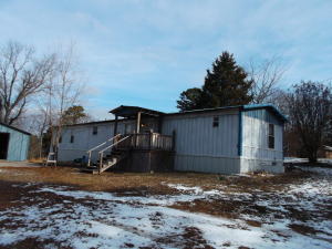 Very nice mobile home with metal roof, has nice covered porch, very spacious rooms, very good condtion. Has large shop area with 3 over head doors. Large front and back yard. Country living but minutes from town.