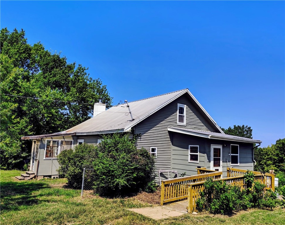 Charming 1905 farmhouse on 2+ acres in Elkins, AR—just 20 minutes from Fayetteville! This 4-bedroom plus bonus room, 1-bath home blends historic character with modern comfort. Features include wood-burning stove, mini-split HVAC, private well with water softener, attached greenhouse, two 55-gallon rainwater barrels, fenced garden, mature fruit trees, medicinal plants, and beautifully landscaped perennials. Two storage sheds and optional chicken coop with hens. Perfect mini farm, hobby farm, or homestead property. Enjoy sustainable living, gardening, or raising chickens in a peaceful setting close to town. Ideal for residents seeking acreage, country living, or a rural property near Northwest Arkansas amenities.