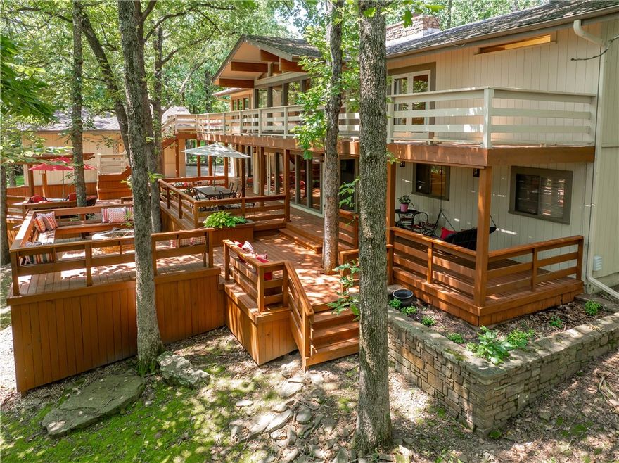 Located in a highly desirable neighborhood, this spacious 2-level home offers comfort, character, and room to spread out. With 3 bedrooms, 4 full baths, and a half bath, the layout features two large living areas—each with a rock fireplace—plus generous built-ins and ample storage. The kitchen includes quartz countertops and a convenient pantry, and a main-floor office provides a dedicated space to work or study. The primary suite features a double vanity and separate makeup vanity. Downstairs, you’ll find an exercise room complete with a private sauna. One of the home’s true highlights is the expansive back deck—perfect for outdoor dining, entertaining, or simply enjoying the peaceful wooded backdrop. Natural light pours in through large windows, giving the home an open, airy feel. An extra lot is included, offering additional privacy and green space. All this, just across the street from the neighborhood pool and tennis courts!