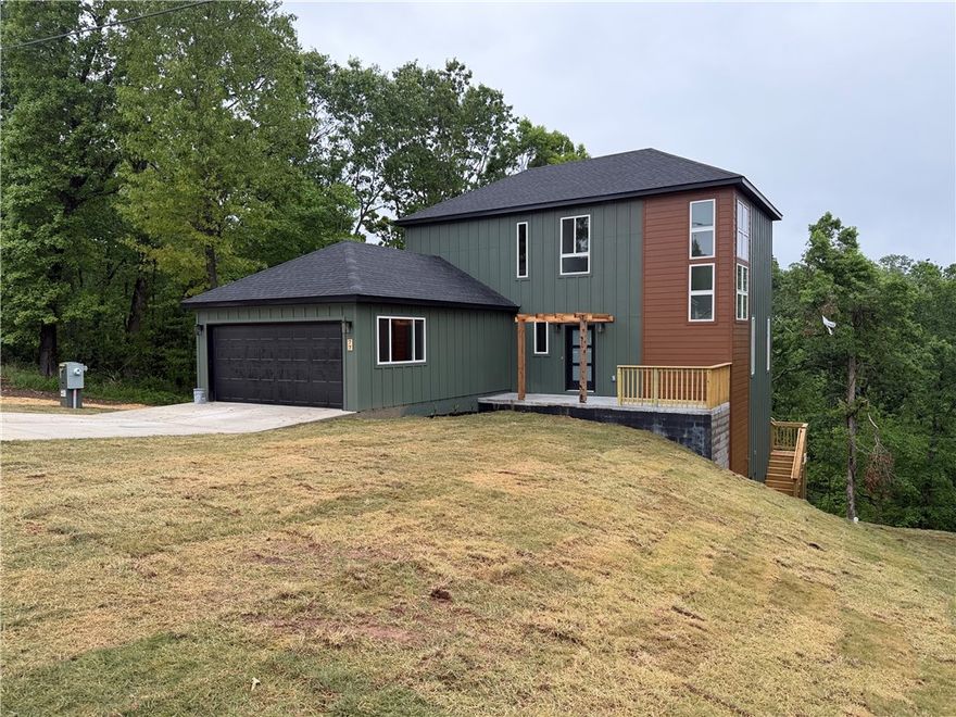 Modern new construction in Bella Vista with beautiful forest views and a stunning contemporary design! Brand new and move-in ready, this home includes a builder warranty for added peace of mind. Featuring an open-concept layout filled with natural light, oversized windows, granite countertops, custom cabinets, a spacious double pantry, and extra storage space under the stairs. The primary suite offers a gorgeous custom tile shower and a relaxing modern feel. Enjoy the private backyard and spacious deck overlooking the wooded setting. Located near trails and Bella Vista POA amenities including golf courses, lakes, pools, tennis courts, clubhouse, and more. A perfect blend of modern living, nature, and comfort just minutes from Bentonville.
