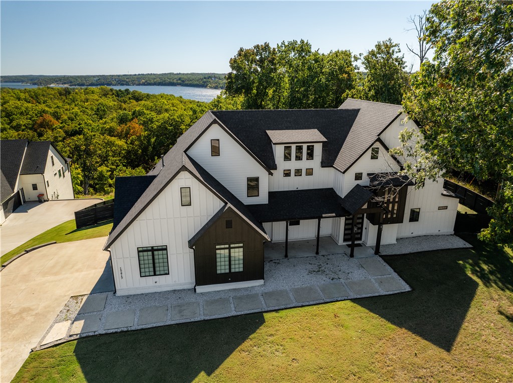 Experience modern luxury and thoughtful design in this stunning 3,991sf custom-built home, completed in 2021 and perfectly situated on 1.36 acres. This move-in-ready residence offers 4 bedrooms, 3 full baths, and a half bath, blending open-concept living with refined finishes throughout.  The chef's kitchen is a showpiece, featuring a 48" gas range with custom vent hood, quartz countertops, two spacious islands, a pot filler, abundant custom cabinetry, and a large walk-in Butler's pantry.  The main level includes two bedrooms (including primary) and convenient dog bath in the laundry area. Upstairs are two additional bedrooms and a bonus room offering flexible living options for guests or family. There is a secondary bonus room w/a hidden room which can serve many options. Outdoor living shines with a covered back patio and outdoor kitchen w/refrig, 36" grill w/rotisserie, Traeger smoker, hot tub, fire table, & rooftop deck w/lake views. 32' boat slip w/HydroHoist lift included