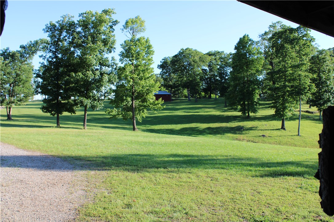 Nature enthusiasts must see this beautiful 30 acre private oasis, with unbelievable views. You will enjoy privacy and seclusion without giving up modern amenities like city water and electricity. A new water line was installed in 2022 using high density polyethylene pipe which has insulating properties to ensure no damage during freezing and thawing cycles. Your 3-bedroom, 1 bathroom cabin comes equipped with a high efficiency 20 seer central heat and air unit which was installed in 2023. The kitchen boasts a side by side refrigerator, stove with double oven, dishwasher, microwave and ample storage. The Electric hot water heater replaced in 2020 is housed in the large bathroom which includes laundry. A double carport of the cabin ensures covered storage for multiple vehicles and lawn equipment. A large barn located has 200-amp electric service and water. The cabin sits above a picturesque, stocked pond. Located a few minutes from Lake Fort Smith and I -49. Magnificent views of mountains.