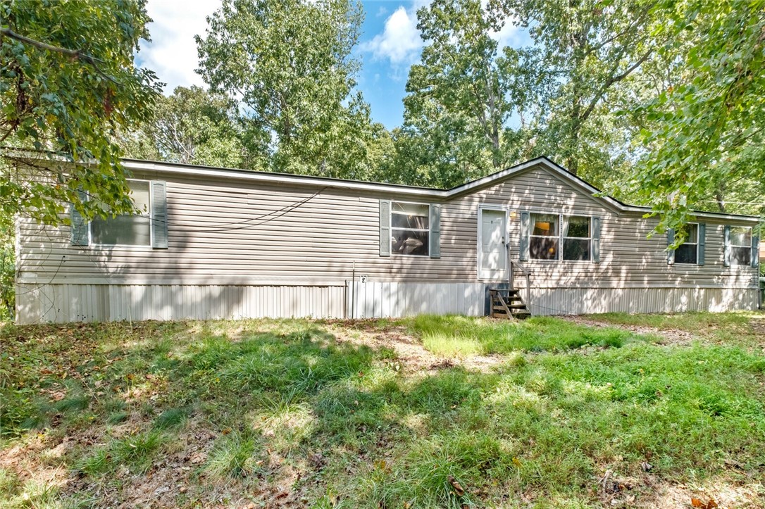If you are looking for a spacious home with a quiet setting, take a look at this 4 bedroom, 2 bathroom home! Floorplan includes both a living room and a large family room with a woodburning fireplace that has space for the entire family to spread out! Large kitchen has a walk in pantry. Updates include new roof in 2021, new heat pump, aluminum venting in 2019, and permanent foundation. Nice wooded 0.84 lot with huge trees and all paved roads to get to driveway. Not a drive by, appointment only please!