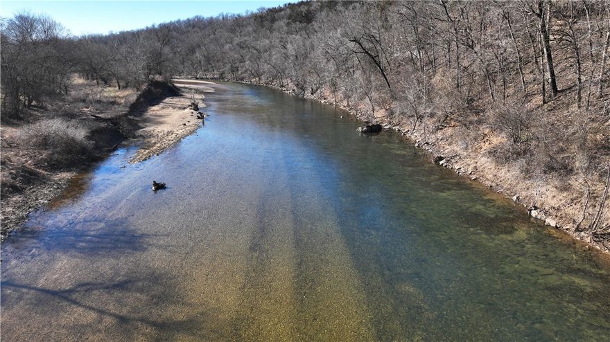 Extraordinary Opportunity! 408 acres of farmland (m/l), just N of Berryville, in Carroll County, AR, has outstanding pastures that are perfect for livestock and hay production. With an abundance of live water, including .5 mile of Clabber Creek on south end and 1 mile of Kings River on the west side. Great water source as well as beautiful. Multiple ponds, and special are the year-round springs. Almost every pasture features a live water source. Grass production is fantastic. Livestock will thrive. Barns on the property will allow for hay storage and easy access during months you feed.  Property also features a set of pipe-working pens that will be handy when working your livestock.  3 bed, 2 bath solar powered home sits atop the highest point overlooking the river bottom. Possibilities are endless.  This one is unique and beautiful and provides a great investment for future development.  The topography provides many opportunities for additional homes and development overlooking the Kings River.