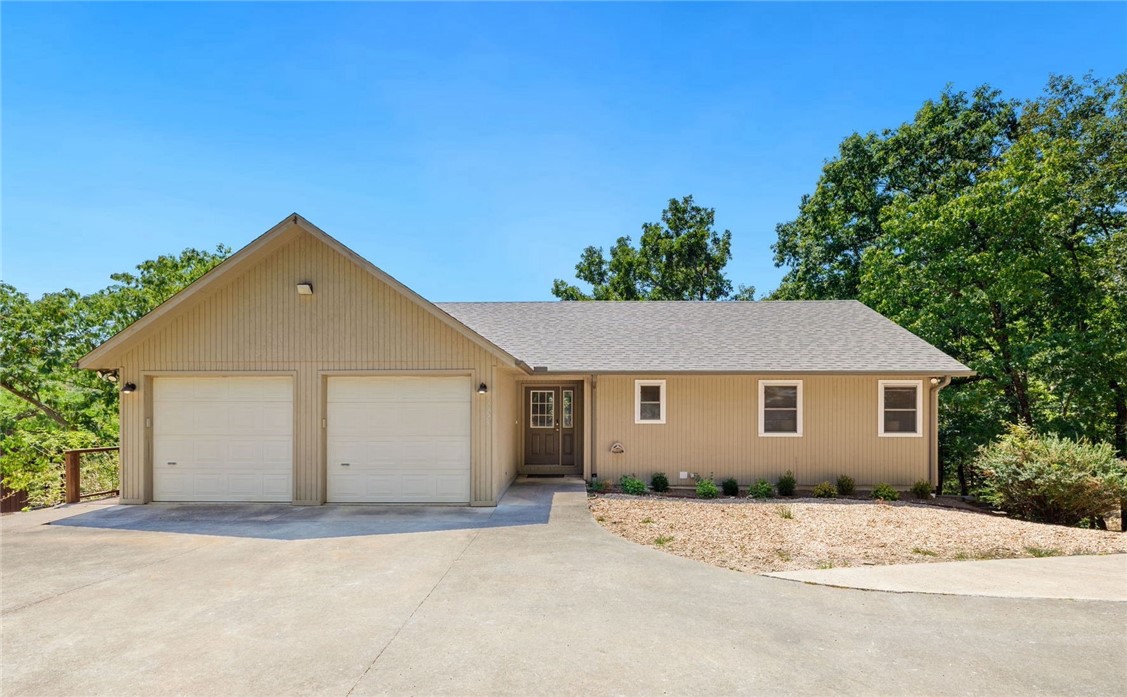 Spend your summer at the lake in this amazing Beaver Lake front home with rare boat slip and direct lake frontage! This gorgeous 4-bedroom and 3-bathroom home is tucked away in a private cove and has a coveted BOAT SLIP a short walk or golf cart ride away and over 200 feet of shoreline for private water access to swim, kayak, or more! The low Corp line allows for a lake deck near the water to enjoy the views and a newly added walkway to it, complete with roped railing for quick and easy access from the house. In addition, the property includes a detached garage built in the same style of the home — perfect for boat storage or a roomy workshop. Interior updates include fresh paint (2024), new quartz countertops in the kitchen (2021), new dishwasher (2024), new roof (2023), new septic system (2024) and recently replaced AC units (2022), rock landscaping (2023) and many more! Don’t miss out on this cozy lake house, perfect for full time residence or a cozy lakeside retreat.