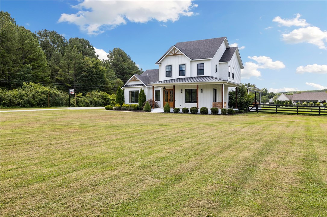 Spacious, custom-built modern farmhouse in East Fayetteville on a fully fenced lot. This 5-Bed/4-Bath home features vaulted ceilings and an abundance of natural light. The stunning kitchen boasts custom cabinetry, quartz countertops, an oversized island and a walk-in pantry and butler's area. Beyond the kitchen, the formal dining room opens up to a wraparound porch through french doors. The guest suite is private and attached to a modern full bath. The primary suite is vaulted with wood beams and opens to a luxurious bath with a free standing tub, dual vanities and separate toilet room. Upstairs opens into a central loft and three bedrooms. One bedroom features an attached full bath and the other two bedrooms are connected by a Jack-and-Jill bath. The Laundry/mudroom features a drop zone and ample storage. The front yard and flower bed feature a fully customizable sprinkler system. The expansive back porch features luxury mechanical screens to block the western sun. Minutes away from the University of Arkansas.