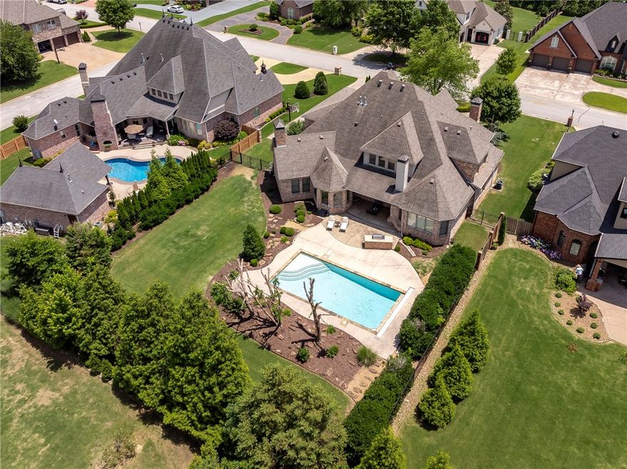 Bentonville Schools! This Pinnacle Country Club estate offers luxury and inviting elegance in this 4 bed, 4.5 bath home!  Enter through a stunning foyer with travertine floors and curved staircase into a vaulted, beamed family room and gourmet kitchen with hearth and breakfast area. Enjoy hand-scraped hardwoods, travertine, and upscale finishes throughout. The private study with fireplace and built-ins, wine room, game room with wet bar, and fully equipped theater offer endless entertainment. The primary suite features a spa-like bath. Outdoor living is a dream with covered patio, fireplace, grill, saltwater pool, and outdoor kitchen—all professionally landscaped. Major updates for peace of mind include: 3 new HVAC units, 2025 tankless water heater, new pool pump, and expanded matching hardwood floors. Style, comfort, and lifestyle all in one exquisite home!