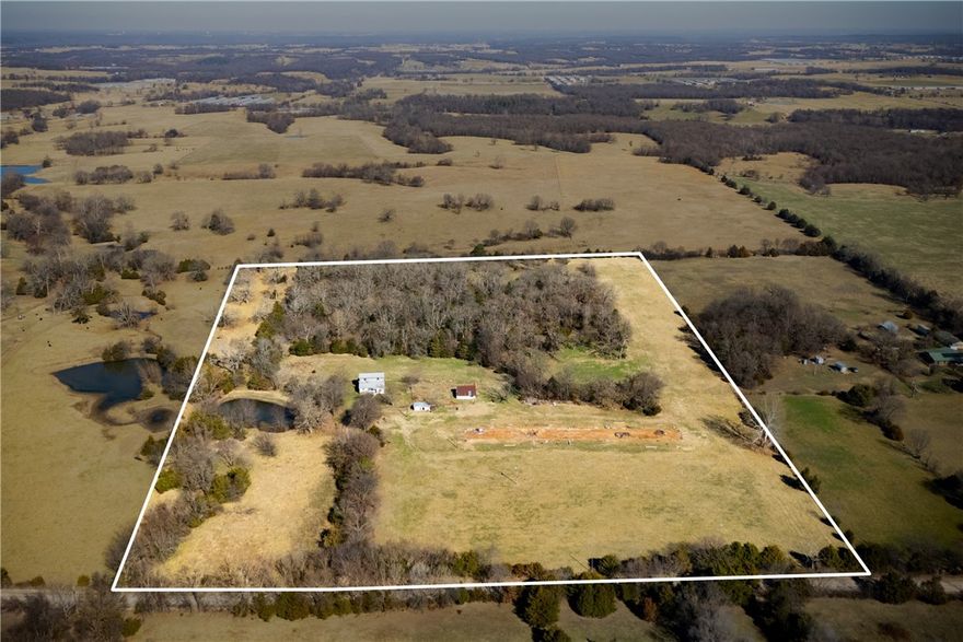 Tucked among trees and open ground, this property feels like the beginning of a countryside tale. A pond catches the light, wooded areas offer shade and privacy, and an old chicken house along with several outbuildings stand ready for their next chapter. The value here is in the land and improvements already in place. An existing home sits on the property and would be considered a project. Whether you dream of gardens, livestock, or a quiet retreat off the beaten path, this setting offers the kind of space where a homestead story could unfold.
