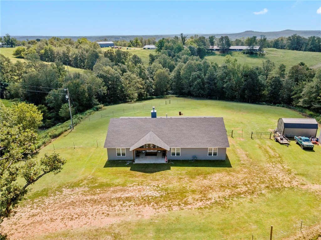 Spacious home with over 2,000 sq ft of living space, perfectly situated on more than 6 acres of land. The inviting living room features a cozy fireplace, ideal for gathering with family and friends. An open kitchen with sleek quartz countertops creates the perfect space for cooking and entertaining. Step outside to a covered patio where you can relax and enjoy the peaceful surroundings. A storage building provides extra space for tools, hobbies, or equipment. This property combines comfort, function, and plenty of room to enjoy the outdoors. Please ask out our fabulous preferred lender credit!