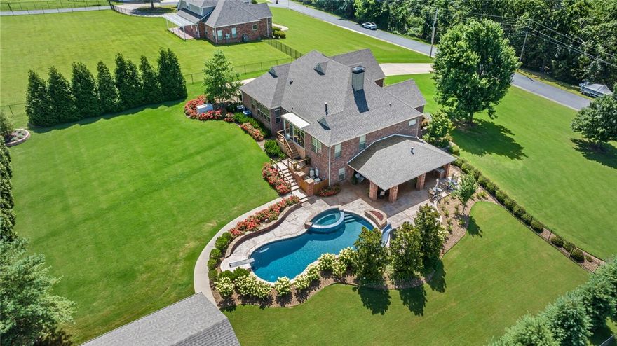 Beautiful lakehome with detached shop, pool, outdoor kitchen, & 2 slips in a private boat dock within a gated lakefront neighborhood! Elegant 2020 remodel includes: cabinetry, appliances, flooring, countertops, fixtures, water heaters, 2 remote-controlled gas fireplaces & a sunroom addition (abundance of natural light!). 3 high-seer HVAC units replaced 2019, 2023, 2025 (two w/humidifiers, one unit zoned for bonus room). Bonus room/4th bedroom. Office/5th bedroom. Media room w/theater seats & wet bar. Gameroom. 2 flex rooms. Open cell foam insulation in the attic for extra efficiency. New roof in 2023! Awesome outdoor living: 24x43 ozone gunite pool & spa, outdoor kitchen w/grill, burners, fridge, & icemaker. Gas fire pit. Detached shop is fully insulated w/foam, new HVAC, full bath, 2 car lifts (turns 4-car shop into 7-car!)  The shop could easily be converted into a mother-in-law suite! Short drive to your dock w/boat lifts & swim deck! Whole-house generator. 1000 gal inground propane tank. Beautifully landscaped!