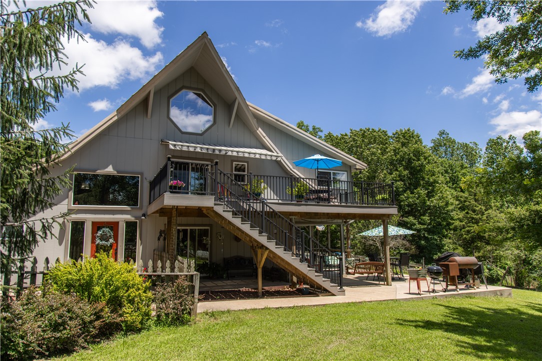Rustic charm meets modern comfort in this beautifully converted barn home on nearly 6 acres, just minutes from Rocky Branch Marina. Featuring pine cathedral ceilings, a newly updated kitchen, and an outdoor elevator from the patio to the second floor, this unique property offers character and convenience. Enjoy stunning pastoral views, a wet-weather creek, and direct walkable access to Beaver Lake—perfect for kayaking adventures. Outdoor living shines with multiple decks, a hot tub, movie screen setup, RV covered parking, a pond, large garden, and additional barn. A one-of-a-kind retreat with space to relax, explore, and entertain.