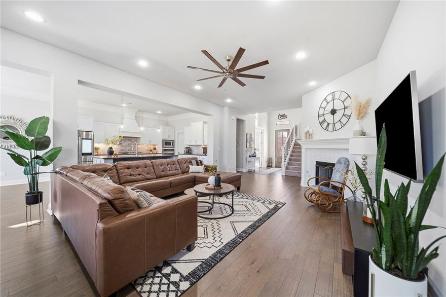 Welcome to this stunning home, thoughtfully designed with a flowing floor plan and abundant natural light.  The kitchen is a true centerpiece with quartz countertops, an oversized accent island with seating, white cabinetry, a gas cooktop, built-in oven and microwave, pull-out storage, and a stylish backsplash. Walls of windows showcase peaceful, tree-lined views from the living room, kitchen, and main bedroom. A dedicated office/den creates a private workspace, while the covered back patio offers a warm retreat for morning coffee or evenings with friends. The smart layout provides seamless easy access between the kitchen, laundry room, and main living areas, giving everyone room to breathe. The main suite features serene views, a tiled walk-in shower, soaking tub, and dual granite vanities. Upstairs, a game room, four bedrooms, and two full baths offer flexible space for hosting, working, or daily living. With quick access to Centerton and Bentonville, this home—blends comfort, function, and location beautifully.