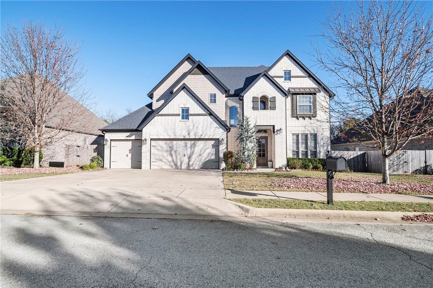 Welcome to this stunning home, thoughtfully designed with a flowing floor plan and abundant natural light.  The kitchen is a true centerpiece with quartz countertops, an oversized accent island with seating, white cabinetry, a gas cooktop, built-in oven and microwave, pull-out storage, and a stylish backsplash. Walls of windows showcase peaceful, tree-lined views from the living room, kitchen, and main bedroom. A dedicated office/den creates a private workspace, while the covered back patio offers a warm retreat for morning coffee or evenings with friends. The smart layout provides seamless easy access between the kitchen, laundry room, and main living areas, giving everyone room to breathe. The main suite features serene views, a tiled walk-in shower, soaking tub, and dual granite vanities. Upstairs, a game room, four bedrooms, and two full baths offer flexible space for hosting, working, or daily living. With quick access to Centerton and Bentonville, this home—blends comfort, function, and location beautifully.