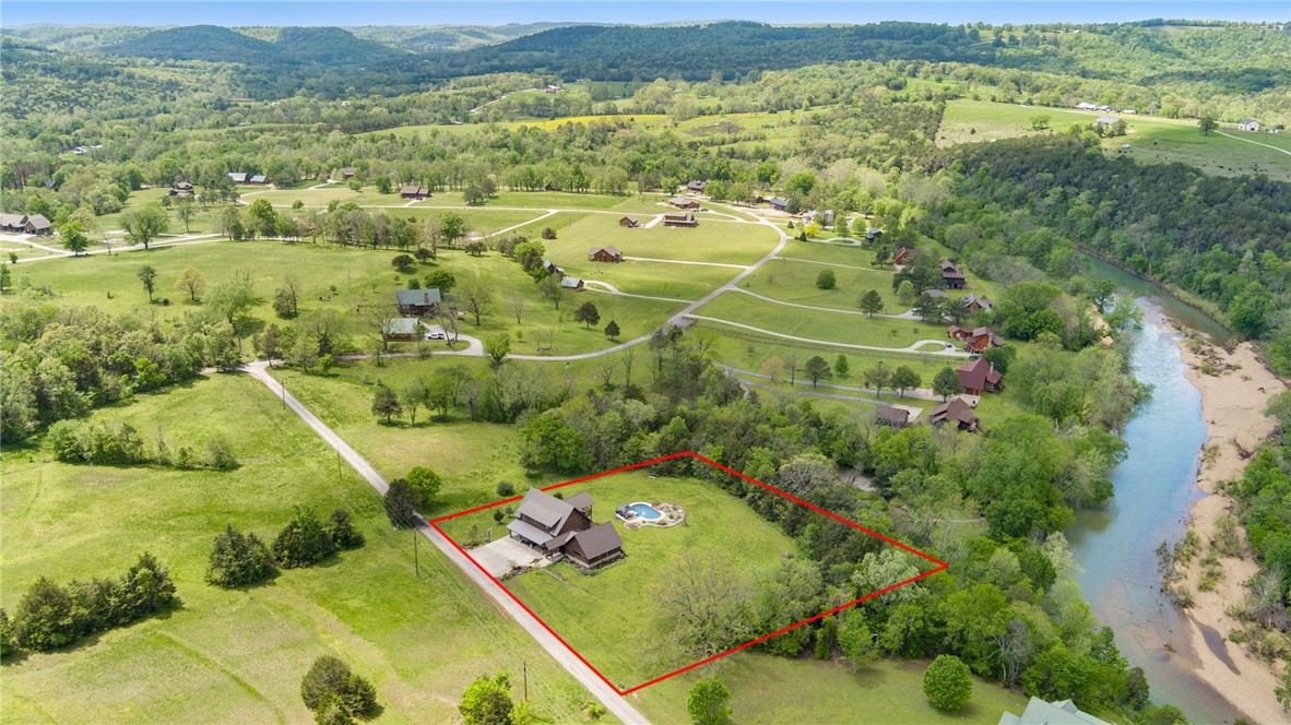 If youāve been searching for a peaceful retreat on the river, look no further! Escape to this serene, natural setting on 1.65 acres in the Riverside at Shady Grove community where residents enjoy floating and fishing from the private gravel bar on the Kingās River; just 15 minutes from Eureka Springs and 5 minutes from the Walmart in Berryville. The current owners love sunsets from the covered back porch, pool, hot tub, and main-level primary suite (added in 2019) where they regularly see deer, turkey, and eagles in this quiet setting. In a floor plan designed for hosting guests and entertaining, 4 bedrooms with 4 en-suite baths are spread out on the two levels, which each include living rooms and flexible spaces. French doors connect the covered front porch to the main level living room, which is plumbed for a second kitchen if desired. This turn-key home comes fully furnished with a full price offer including kayaks, boat trailer, and side x side! Schedule a tour today!
