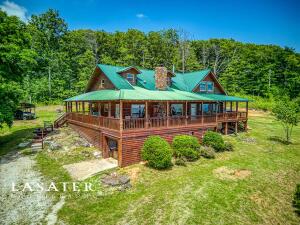Welcome to your dream retreat nestled among the beautiful Ozark mountains. This remarkable cedar log cabin offers a unique blend of rustic charm and modern comfort, situated in an idyllic location with panoramic views of the Arkansas grand canyon. This home offers two master bedrooms downstairs, a 3-section loft that can be used for up to 3 additional bedrooms, 3 full bathrooms, 1 half bath, central air/heat, large propane fireplace, wood burning stove, whole house generator and an additional fully furnished guest apartment within the detached garage. All appliances and some furniture will convey. Ask listing agent for more info.