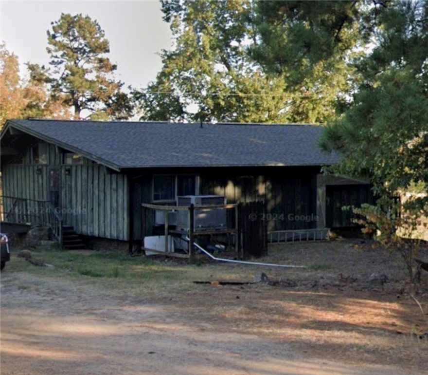 Modern lines and timeless character define this 1972 home, showcasing vaulted ceilings, walls of windows, exposed wood beams, and a striking central rock fireplace that anchors both levels. The open, airy design gives off mid-century modern vibes, enhanced by wood siding and a balcony overlooking the lush 1.65-acre lawn. Recent updates include a refreshed main bath, new flooring, and a roof that’s approximately five years old. The lower level offers a spacious den/family room/master suite with an adjoining bath featuring a custom rock walk-in shower and convenient walk-out access to the backyard. A huge patio provides the perfect space for entertaining, or the flexibility to add a garage if desired. A storage building is included, and while the home needs only minor repairs, it presents a rare opportunity to add your own finishing touches to a truly unique property.
