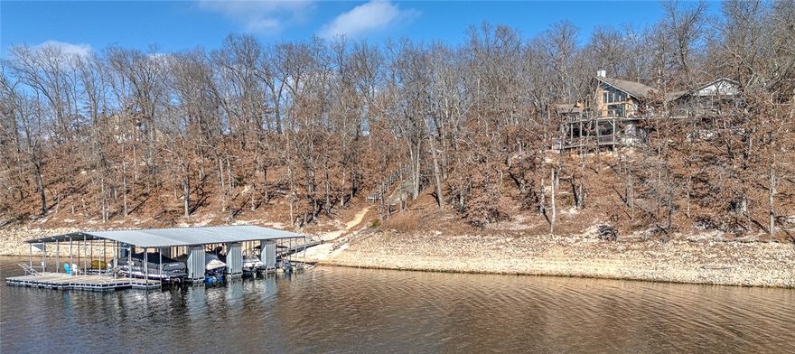 This architectural lakefront home has everything you've been looking for - an easy walk to the water, panoramic views, a boat slip - and more! This 1.5 acre property offers 200 ft of shoreline, a 3,508 sqft main house w/ 3-beds & 3.5-baths and a detached garage w/ 1-bed/1-bath mother in-law's suite. Both have been updated with modern touches like quartz and granite counters tops and all bedrooms have lake-views and deck access. Just a short gentle walk to your 10x24 covered boat slip in the community dock. Entertainment spaces abound indoors and out with an expansive two-level deck, large fire pit, and hot tub (which conveys!). Inside, relax in the spacious upstairs living room by the fireplace or downstairs in the basement game room. Current owner's operate the main house as a highly-rated short-term rental. Offset the cost of ownership by continuing or rent the ADU long-term. Located in a quiet cove off Coose Hollow, this property is a short boat ride from Prairie Creek Marina and 25 minutes from Downtown Rogers.
