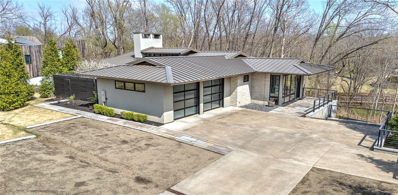 Welcome to Downtown Bentonville’s most incomparable residence! Nestled on a .47 acre scenic lot overlooking Crystal Bridges Museum of American Art, this masterpiece was meticulously designed by acclaimed architect, Sarah Susanka. The thoughtfully crafted layout blends sleek modern aesthetics with open, flowing spaces, ideal for both entertaining and everyday comfort. Floor-to-ceiling windows capture breathtaking skyscape views, filling the home with natural light and an effortless sense of elegance. Main floor boasts a sleek chef’s kitchen, multiple outdoor living spaces, a sun-filled dining space, living area w/ stone veneer fireplace, study/library, and a primary suite w/ incredible views and a spa-like bath. Lower level hosts a workout room w/ Pilates wall, media room, sitting area w/ wet bar and access to lower porch, 2 bedrooms w/ a shared full bath and a 413 sq ft in-law suite w/ private entrance. Experience an unparalleled level of craftsmanship just minutes from all of Bentonville’s main attractions!