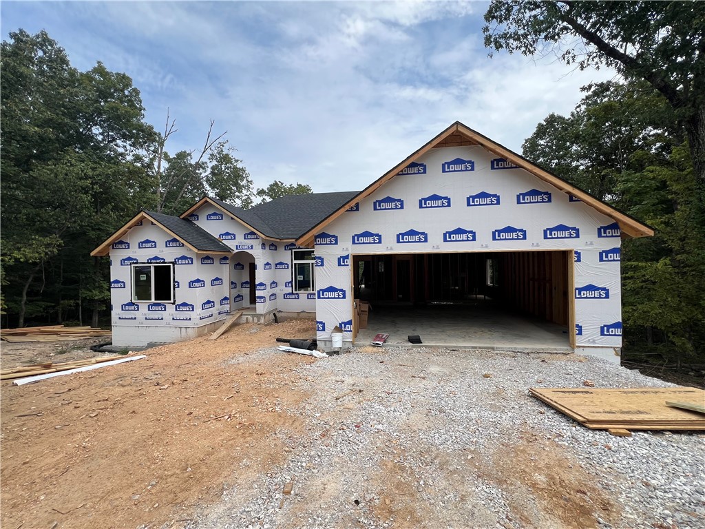 Lock in pricing now and make this gorgeous new build by Elite Thomas Homes your own with personalized finishes and upgrades! Conveniently located on Bella Vista’s east side—just off Lancashire/340 and less than a mile from the popular Back 40 Trailhead—this home combines traditional design with natural surroundings. Inside, you’ll find 3 bedrooms, 2 bathrooms, plus a dedicated office and an oversized 2-car garage. The main living area boasts 11’ ceilings, a striking stacked-stone vent-free gas fireplace, and hardwood floors that flow through the entry, living, hallway, and primary suite. The additional bedrooms and office feature plush carpeting for comfort. The luxurious primary bath includes a dual vanity and a spacious tiled shower with dual shower heads. Step outside to a private back deck overlooking wooded common property—no neighbors behind you, and both side lots currently vacant. Estimated completion: Early November 2025. Contact me today for the full list of planned features and available upgrades!