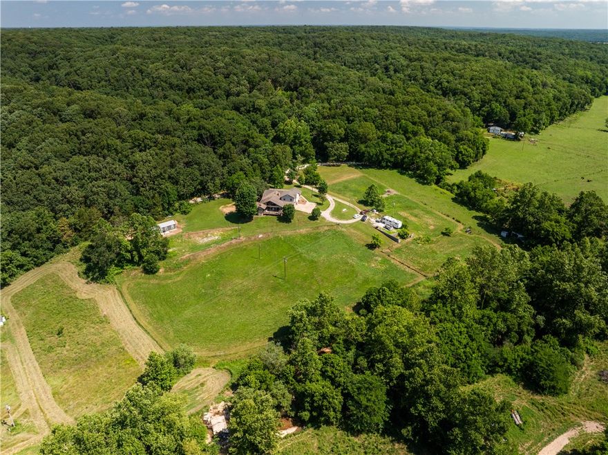 Do you need lots of space in the country and enjoy entertaining? This spacious home on 5 beautiful acres could be yours! Neighbors creek is a few feet of the border.  There are over 3,000 sq. ft. of living space.  There are two primary suites.  One is on the main level and one on the second level. Family room has skylights for added brightness and a pellet stove to warm those cold nights. The kitchen is spacious and comes with a gas range.  Adjoining the kitchen is a bright sunroom.  But wait, the massive covered patio with outdoor kitchen is ready for outdoor entertaining. Have a business from home with a large office space.  Off the patio is a spiral staircase leading to a spare room that would make a great playroom.  A tiny home with kitchen, living, bedroom and bath are included for your guests who will be wanting to join you in the peaceful country.  Roof is 8 years old, new water heater in 2023, 40k HVAC system in 2022. Dogs will be put up for showings but they are very friendly.