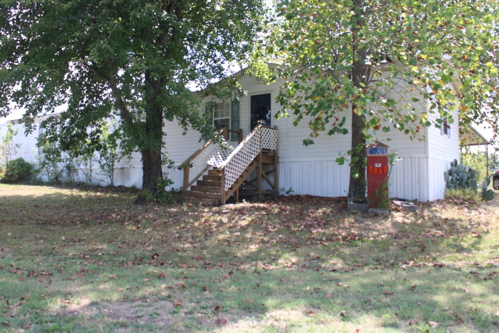 Country Living in Bergman School District on Paved Road about 20 minutes from Harrison. 2 bedroom 2 bath 16 x 70 ft Southern Estates single wide manufactured home with covered rear deck, detached double carport, storage building, and concrete block building built and used as a milk barn could make a great workshop. Home has living area open to kitchen/dining with vaulted ceiling, nice kitchen cabinets, island, pantry, & utility room. Split bedroom plan, primary bedroom has large bath and walk-in closet, central heat and air plus propane backup space heater. Copy of recent survey in Documents. Only $95,000 - Come see today!!