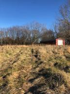 Nice level lot close to town with paved frontage. This lot comes with a 16 x 40 metal shop building. Come check out this lot today! Buyer to confirm all utilities.
