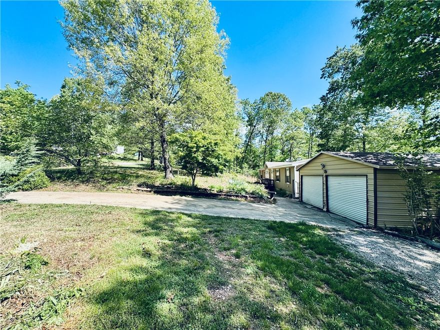 Lake Area Gem! Spacious 3 bedroom, 2 bathroom manufactured home on 1.77 acres with a large detached 2-car garage. Built in 2005 and offering 1,568 sq ft of comfortable living, this home provides the perfect blend of rural living and modern convenience. Just minutes from the hustle of Northwest Arkansas, yet it feels miles away from it all. Enjoy the large, fully fenced yard with plenty of room for outdoor enjoyment, gardening, or relaxing on the deck. The property features an eat-in kitchen, walk-in closets. Located in the desirable Beaver Lake area, you're only minutes from lake access while staying close to Rogers, Bentonville, shopping, and dining. This  home on a beautiful 1.77-acre lot is ready for its next owner. Don't miss this rare opportunity for country living with NWA convenience!
