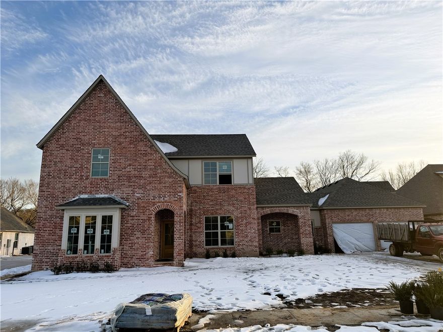 Stunning new construction two-story home designed with refined family living in mind. The open-concept living area flows to a covered porch with fireplace, creating a perfect blend of indoor-outdoor comfort. The kitchen is thoughtfully positioned between a formal dining room and a light-filled breakfast area, ideal for both entertaining and everyday living. A convenient mudroom off the garage adds effortless functionality.

The primary suite offers a spacious bath and walk-in closet, serving as a private retreat. Upstairs features a media room for elevated movie nights and additional bedrooms and baths. The home includes five bedrooms and four full bathrooms, with garage plumbing in place for a future bath.

An exceptional garage offers the option for a four-car tandem layout (come see!), plus stair access to unfinished storage space above—providing flexibility, storage, and long-term value.

This property requires GSP per City of Fayetteville.