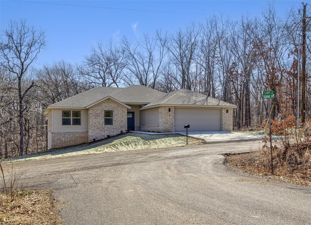 Located near Loch Lomond lake! Enjoy Bella Vista's Back 40 & community amenities including golf, hiking and fishing. 3 bedrooms, office, and large living room with modern electric fireplace/ Built-ins between laundry & garage for coats, shoes, and organization. Main suite with double sinks, enclosed toilet, walk-in shower, and spacious closet. Granite counters, island, stainless appliances, designer lighting, and hexagon tile backsplash in kitchen. Large usable yard surrounded by trees and covered back deck.