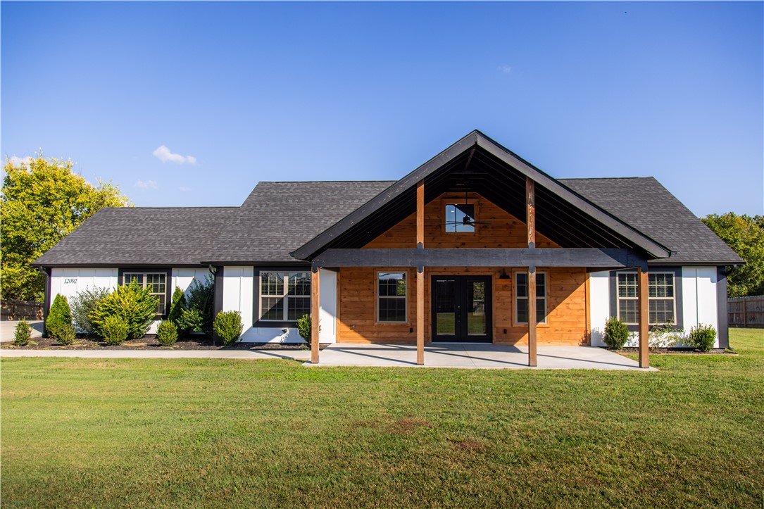 Welcome to 12092 Guyll Ridge Road, where rustic charm meets modern comfort. This beautiful, nearly new home features an open-concept layout with vaulted wood ceilings, luxury vinyl plank flooring, and a striking stone fireplace. The kitchen shines with quartz countertops, stainless appliances, rich cabinetry, and a warm wood island centerpiece. The primary suite offers a spa-like bath with dual vanities and a tiled shower. Enjoy mornings under the inviting front porch or evenings on the private back deck with scenic views on your one acre lot. Nestled just 10 minutes to Beaver Lake, 15 minutes to Downtown Rogers, and 25 minutes to Bentonville, this home offers convenient access to dining, shopping, and the region’s top employers while maintaining a quiet country feel. Move-in ready and beautifully finished, this is Northwest Arkansas living at its best.