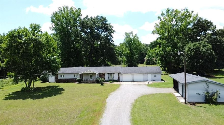 A little piece of country in the Mountain foothills. This beautiful custom built, 3 bedroom 2 bath home is nestled just as you begin the climb up into the Ozark Mountains. Home sits on 7.89 acres m/l with a park-like back yard where you can sit inside the screened porch, open deck or on a swing watching wildlife, while listening to a babbling stream with a footbridge crossing into a field containing a rustic barn. Home has a 2 car oversized garage, additional workshop, equipment shed, and storm shelter. The inside has an inviting fireplace, custom cabinetry, built in closet shelving, large walk in primary closet, alarm system and tons of storage thorough-out. New HVAC in 2024. New flooring throughout 2021. New roof 2022. Seller providing a Home Warranty.