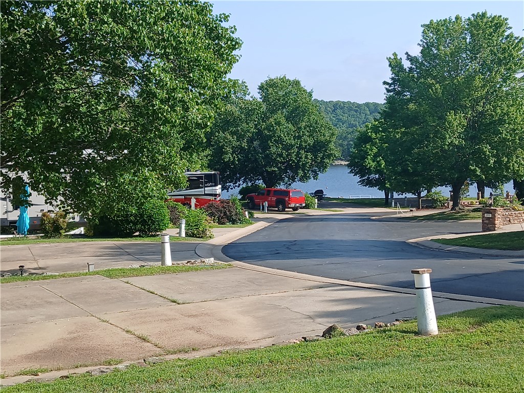 -- This back in lot could be called one of the largest lots available in the RV resort for both usable space and entertainment value! Lower patio will have you falling in love with views and the fun of haggling your neighbors as they pass by on evening strolls. The gated upper patio is one that will be favored by fur babies, provide safety for little ones and that grill loving person in your life will be thanking you over and over again. Outdoor kitchen with water, offers lake views, shade trees and plenty of room for patio furniture. The Lot will accommodate a 45 ft 5th Wheel trailer - not only does it fit nicely but it also allows plenty more space for additional parking. Meet your next adventure at Table Rock Lake