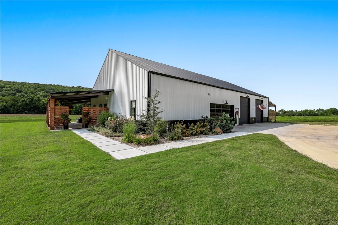 Experience modern living in this stunning Barn dominium on 10 acres, featuring 1 bedroom, 1.5 bathrooms, and a 2-car garage. The home boasts 10 ft. ceilings throughout, a gourmet kitchen with CafƩ Profile appliances, quartz countertops, a dual-tier stainless steel sink with basket strainer, colander, and cutting board, a pot filler, and a walk-in pantry with a sink and prep station. Custom floor-to-ceiling cabinets. This high-tech smart home allows you to control lights, appliances, showers, and locks effortlessly. Enjoy oak engineered wood flooring throughout, with tile in all wet areas. Unique features include double iron front doors, glass garage doors, and a 220 amp plug for an electric car charger. The heated shop section offers, 220 amp plugs on every wall, LED lighting, 3 hose bibs, 5 floor drains, and 1,100 sq. ft. of storage above the home. The reinforced concrete floors are designed for lift pads. Outside, relax on the large, covered patio, enjoy the spring-fed pond, and explore the wet weather creek.