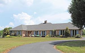 This exceptional estate was designed for making memories and enjoying the very best that country life has to offer! With 27.8 fenced acres of beautiful land, a large stocked pond, a winding creek, and a 30x50 barn with power and water, you will love the setting this home has to offer. Inside the spacious home you'll find a large formal living and dining area, and a beautiful kitchen with adjoining breakfast nook and a cozy family area. The amazing master suite features a private sitting area with charming fireplace, a beautiful master bath with both walk in shower and jacuzzi tub, and a separate entrance to the large deck that runs the length of the back of the home. All this is minutes from scenic lakes and excellent fishing! There is even power and water set up for an additional home