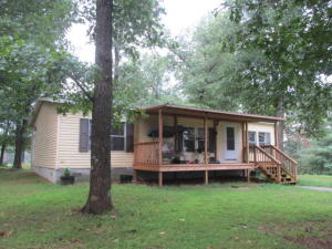 Private location and hid from the road you'll find this well kept manufactured home set up on permanent foundation with concrete block skirting, should pass any loan type. Home has sheet rock walls with rounded corners, nice living area, kitchen dine combination, and large utility room. Rear deck and covered front porch, good storm cellar, large pole outbuilding.