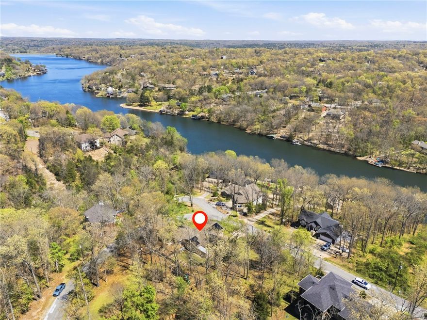 Welcome to 57 Chelmsworth Dr in Bella Vista, AR! This charming 3-bedroom, 2-bath home sits on 3 parcels totaling 0.81 acres, offering space, privacy, & flexibility. Enjoy beautiful views of Lake Windsor right across the street from the sunroom & take advantage of the convenient proximity for outdoor recreation with Tunnel Vision bike trail just a mile away! Inside, you'll find a fantastic open layout. Relax by the fireplace in your living room...OR...by the one in the primary bedroom! The recently-remodeled kitchen invites you to hang out at the massive counter peninsula. The home features a spacious 500+ square foot exterior deck—perfect for relaxing, entertaining, or soaking in the scenery. The 2 additional parcels provide a variety of enjoyment options. Solar panels on roof & new HVAC provide energy efficiency & reduced utility costs. Make this property with its scenic setting & generous lot size yours! 5 min to picnic area & park at Lake Windsor; 10 min to shopping, restaurants & OZ TRAILS BIKE PARK & LIFT!