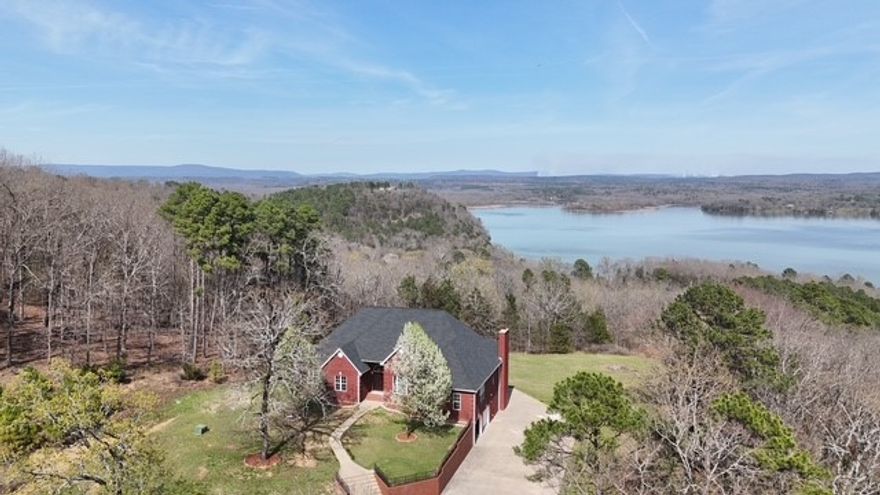 Discover a rare blend of superior craftsmanship, privacy, and spectacular water views with this custom-built, one-owner, home on 5+ private acres overlooking Piney Bay on Lake Dardanelle. With 5 beds 3 bath &  4,725 square feet of living space. Inside, you’ll find exquisite hand-milled locally-sourced cherry wood floors and rare, burled cherry wood cabinetry. Basement living space offers a fireplace, wet bar, hand-milled local pine wood walls & cabinetry complemented by a striking walnut mantel and beam.The primary suite offers a luxurious jetted tub, while the mother-in-law apartment provides space for guests or multigenerational living. Step outside to enjoy the expansive deck and patio to soak in the spectacular panoramic water views. Additional features include 2x6 wall construction, safe room, fiber optic internet, city water, 220 power, ATV/motorcycle storage and workshop area. Recent upgrades include a new roof, new HVAC, fresh interior & deck paint, new LED lighting, and plumbing fixtures. Call today!