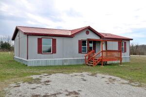 Large manufactured on a half acre lot surrounded by pasture on pavement near Alpena.