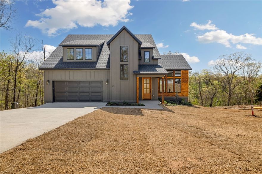 Stunning new construction near Lake Lomond in Bella Vista! This 3 bed, 2.5 bath home blends modern design with warm, natural finishes and thoughtful upgrades throughout. Hardwood floors flow seamlessly across the main and upper levels, creating a cohesive, high-end feel. The chef's kitchen is a true showstopper, featuring quartz waterfall island, custom cabinetry, designer lighting, subway tile backsplash, gas range, and abundant storage-perfect for entertaining or everyday living. The private primary suite offers a spa-like bath with dual vanities, soaking tub, tiled walk-in shower, and elegant gold fixtures. Enjoy the convenience of a laundry area in the primary closet plus a full upstairs laundry room. Upstairs you'll also find a versatile loft and dedicated office space. Relax on the covered deck overlooking serene, wooded surroundings just minutes from Lake Lomond.