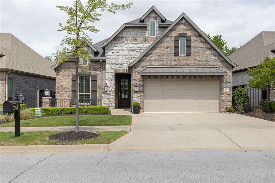 Adorable home in East Fayetteville’s Cottages at Old Wire.  2,543 heated and cooled sq ft includes 4 bedrooms (of which 3 are on the MAIN level), 3 full bathrooms, open eat in kitchen to living, and separate laundry.  Amenities include hardwood floors (NO CARPET except for stairs), full tile surround showers in primary and downstairs guest bathroom, full tile walls in the kitchen, large walk in pantry, built in oven and microwave, 5 burner gas cooktop,  gas log fireplace, beautiful covered patio, small yard, flagstone patio, fully fenced backyard, and a 2 car garage.  All landscaping, mulch, irrigation, and yard mowing is included in POA dues!  This is truly a move in ready, lock and leave home with a versatile floor plan!  Centrally located in Fayetteville with easy access to Razorback Greenway and Root Elementary School.