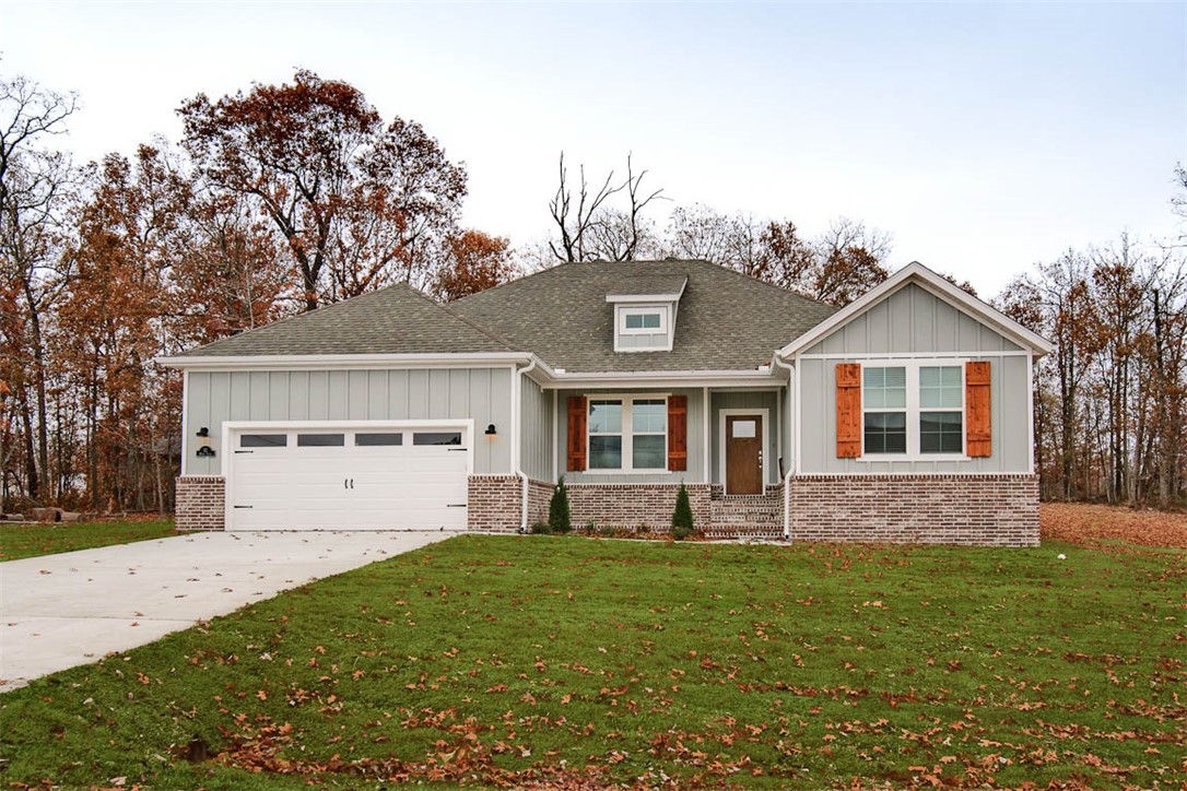 New Construction on a LEVEL .34 ACRE LOT AND DOWN THE STREET FROM THE BLOWING SPRINGS GREENWAY & TRAIL CROSSING! Quick access to Bentonville. Features include a split floor plan, gas fireplace, LVP throughout, vaulted ceiling w/ beams, 3 cm counters, custom cabinets w/ wood hood, gas range, pantry, oversized eat-in kitchen, and high-end finishes throughout! Primary bath includes a large walk-in tile shower, free-standing soaking tub, double vanity, and generous closet space! Spacious covered patio area in both the front and back is ideal for entertaining! Approx completion date is 6/30/25 **Pictures may not be of exact unit listed, colors may vary slightly.