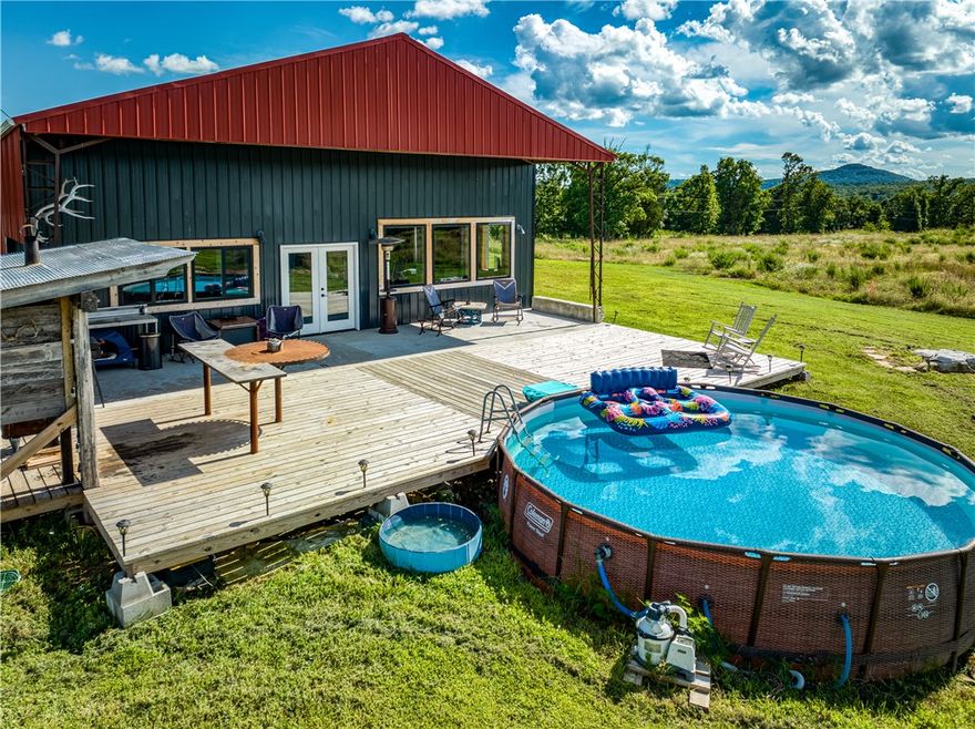 Ozarks living at it's finest! This hay barn converted into an extraordinarily unique 1 BR 2 BA barndominium checks all the boxes! Phenomenal mountain views from the massive back patio, newer pool to relax in on those hot summer days, an outdoor kitchen, very tasteful details (custom kitchen island, handcrafted heat plate with gorgeous mantle behind the wood stove, 100+ year old logs make up the stairs, custom bathrooms...) on the inside...this one is a must see. There is a good mix of woods and cleared property on the 54.33 acres and there are two small ponds. And did I mention the views????